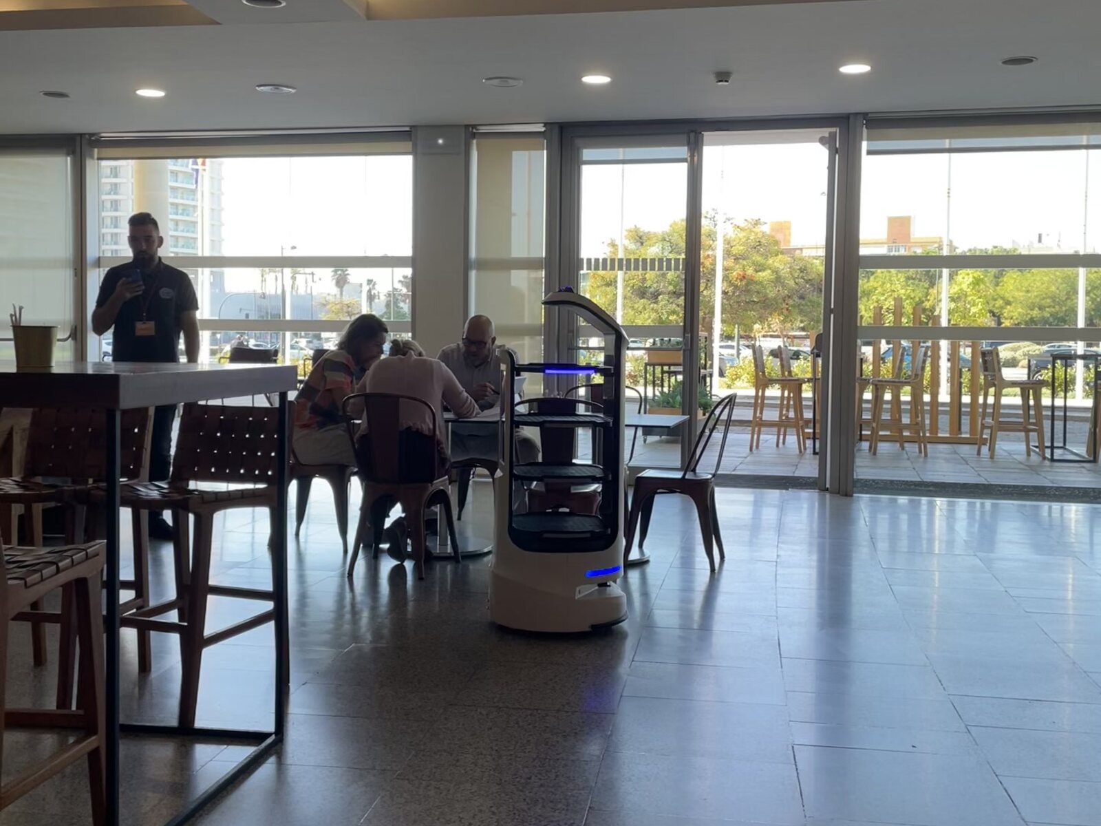 The waiter robot moving through the cafeteria alongside visitors and venue staff
